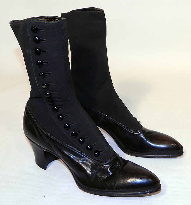 Unworn Victorian Black Wool & Leather High Top Button Boots Poehlman Shoe Co. They are made of a supple black leather bottom shoe, with a black wool fabric top. The boots have pointed toes, 15 black shoe buttons along the side for closure and stacked black wooden cube heels.