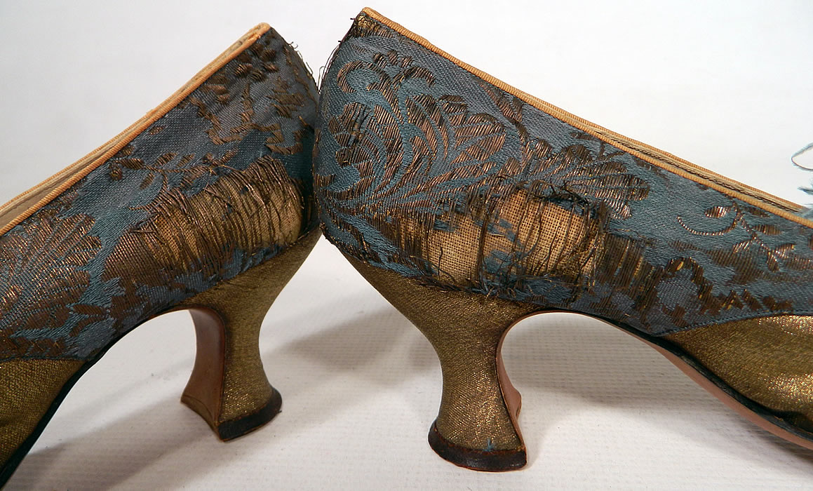 Edwardian Titanic Blue Silk Gold Lam&eacute; Damask Brocade Feather Trim Shoes. They have been gently worn and are in as-is fair condition, with several frayed splits on the blue silk brocade fabric back side heels and some molting missing feathers (see close-up).