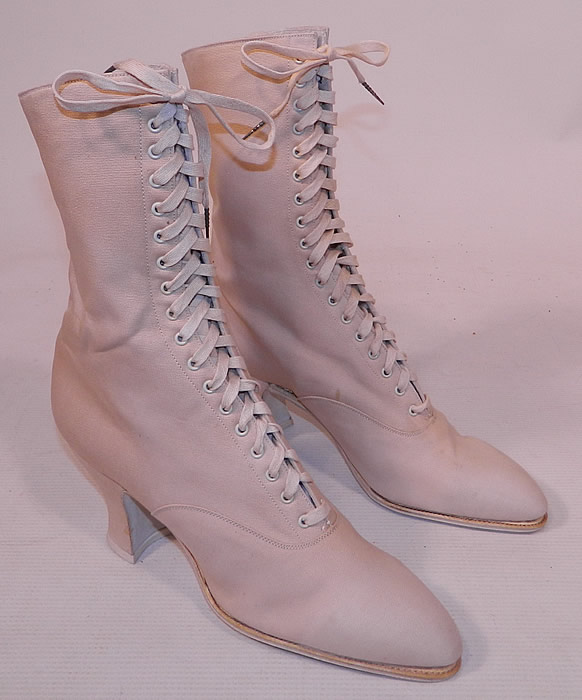 Unworn Victorian Vintage White Cream Canvas High Top Lace-up Boots Shoes
These beautiful boots have slightly pointed toes, the original white shoe string laces for closure and canvas covered French Louis XV spool heels. The boots measure 9 1/2 inches tall, 10 inches long, 2 1/2 inches wide, with 3 inch high heels. These antique boots are difficult to size for today's foot, but my guess would be about a US size 6 or 7 narrow width. 