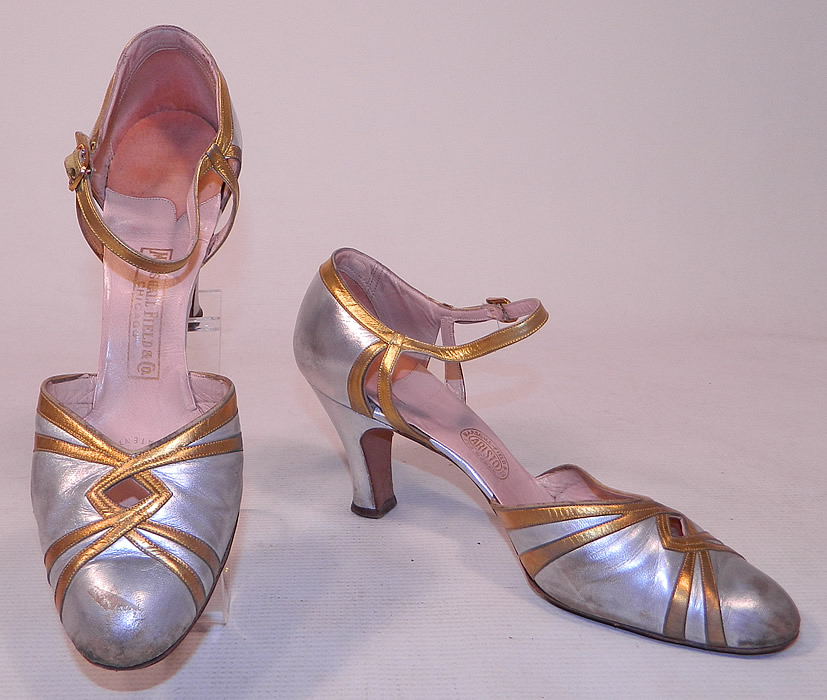 Vintage Marshal Field & Co Aristo Art Deco Silver Gold Leather Ankle Strap Evening Shoes
These elegant evening flapper dance shoes have decorative Art Deco designs, a key hole peek-a-boo opening on the front instep vamps, adjustable ankle straps with rhinestone gold buckle closures and silver leather covered modified boulevard high heels.