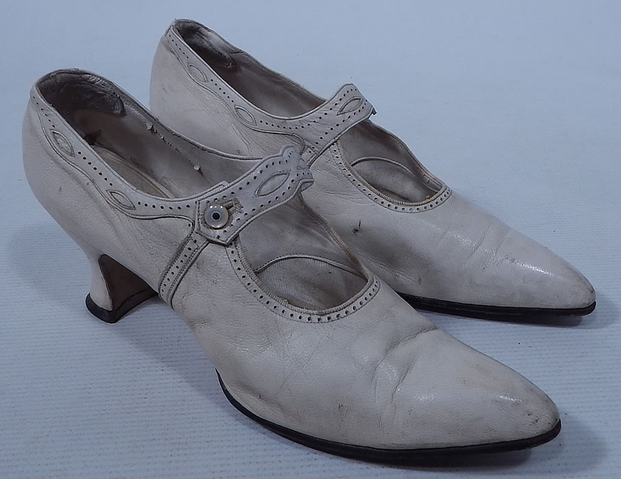 Edwardian Vintage H.H. Tuttle Co. White Leather Button Strap Mary Jane Shoes
This pair of Edwardian era vintage H.H. Tuttle Co. white leather button strap Mary Jane shoes date from 1910. They are made of a white leather with decorative punch work and eyelet trim.