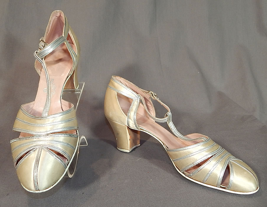 Vintage C. Crawford Hollidge Shoe Salon Cream Silk Satin Silver Leather T-Straps
These beautiful bridal wedding, evening shoes have a T-strap style, with an adjustable ankle strap buckle closure, peek-a-boo cutwork straps on the front toes and satin covered modified boulevard high heels.