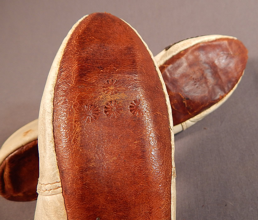 Vintage Turkish Ottoman White Kid Leather Gold Purlwire Embroidered Slipper Shoes
These opulent ladies slipper style slip-on shoes flats have pointed curled toes and hard leather straight soles stamped on the bottoms with asterisk symbol star shape designs.