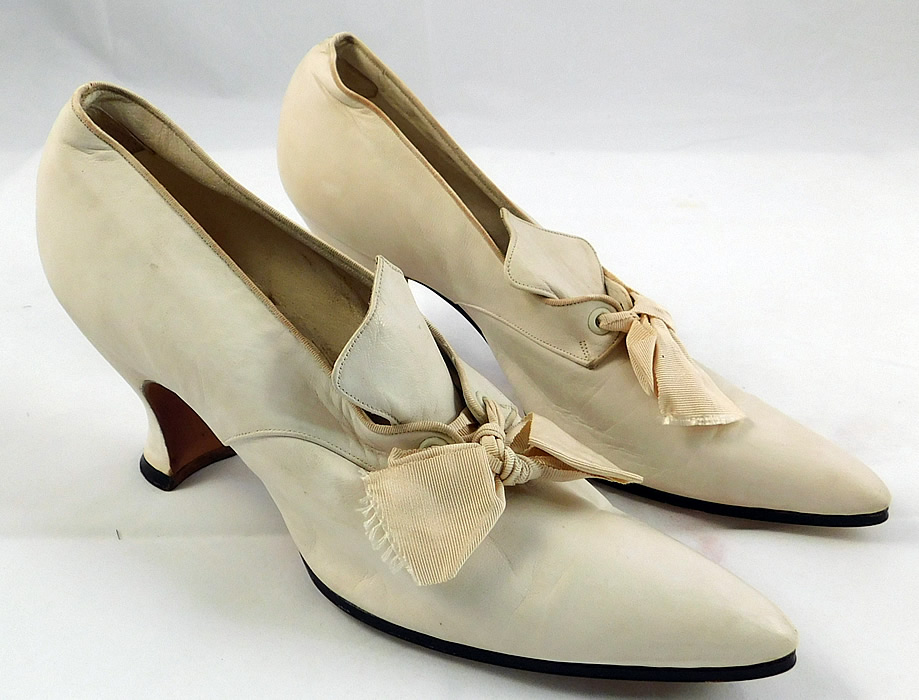 Edwardian Vintage La Valle & Lo Presti White Kid Leather Pointed Toe Shoes
These wonderful womens wedding shoes have a slip on slipper style have a decorative tongue top, cream silk grosgrain ribbon bow tie lacing closure, elongated pointed toes, kid leather covered French Louis XV heels, lined in leather