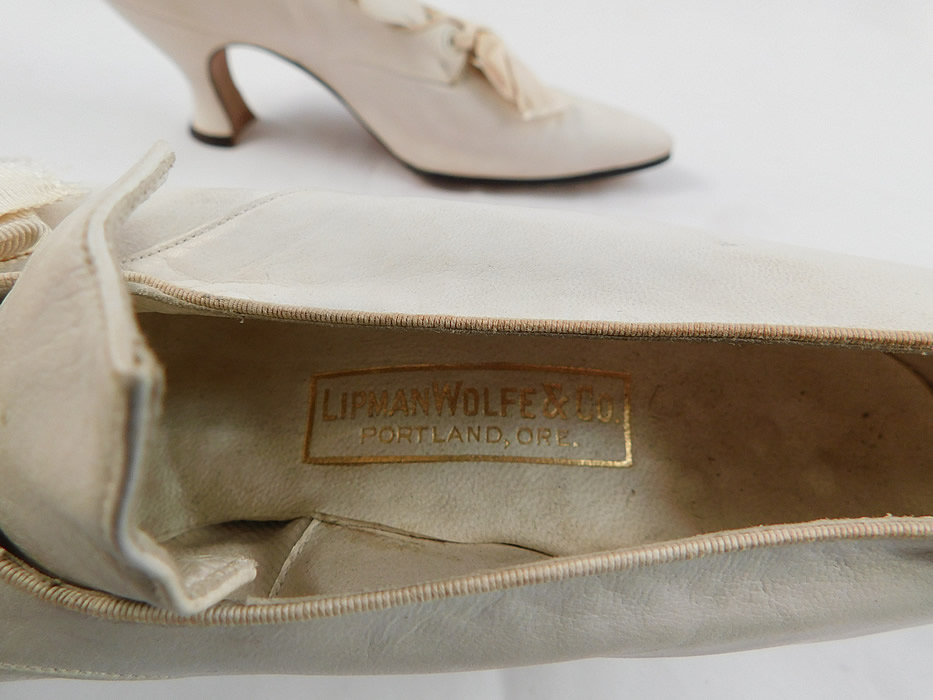 Edwardian Vintage La Valle & Lo Presti White Kid Leather Pointed Toe Shoes
These wonderful womens wedding shoes have a slip on slipper style have a decorative tongue top, cream silk grosgrain ribbon bow tie lacing closure, elongated pointed toes, kid leather covered French Louis XV heels, lined in leather with gold embossed lettering labels inside from "La Valle & Lo Presti Makers N.Y." and the "Lipman Wolfe & Co. Portland, Oregon" department store.