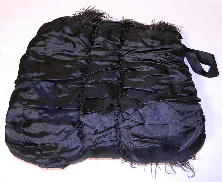 Victorian Black Silk Ostrich Feather Plume Trim Winter Muff Hand Warmer. The muff is a large size measuring 15 by 13 inches. It is in good condition, with only a tiny hole near the bow trim. 
