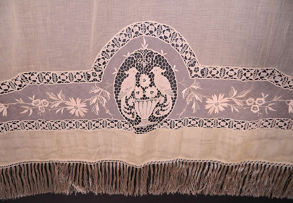 Victorian Antique Point de Venise Lace Floral Bird Net Fringe Drapery Curtain Panel. There is Point de Venise lace with buttonhole stitches, a hexagonal meshwork oval medallion with a pair of birds and a floral urn decorative design, a Reticella lace trim border, with embroidered floral vine leaves and fringe trim ends.
