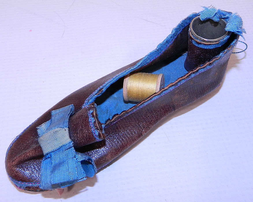 Antique Victorian Sewing Shoe Etui Needle Case Thimble Holder. It has implement tools which include a silver thimble, spool of thread and needle cases.
