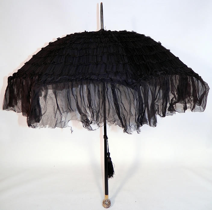 Edwardian Black Silk Ruched Ebony Amethyst Jeweled Handle Parasol. This Edwardian era antique black silk ruched ebony amethyst jeweled handle parasol dates from 1910. It is made of black silk chiffon fabric with decorative ruched tucks, gathers, pleating and a sheer ruffle trim edging.