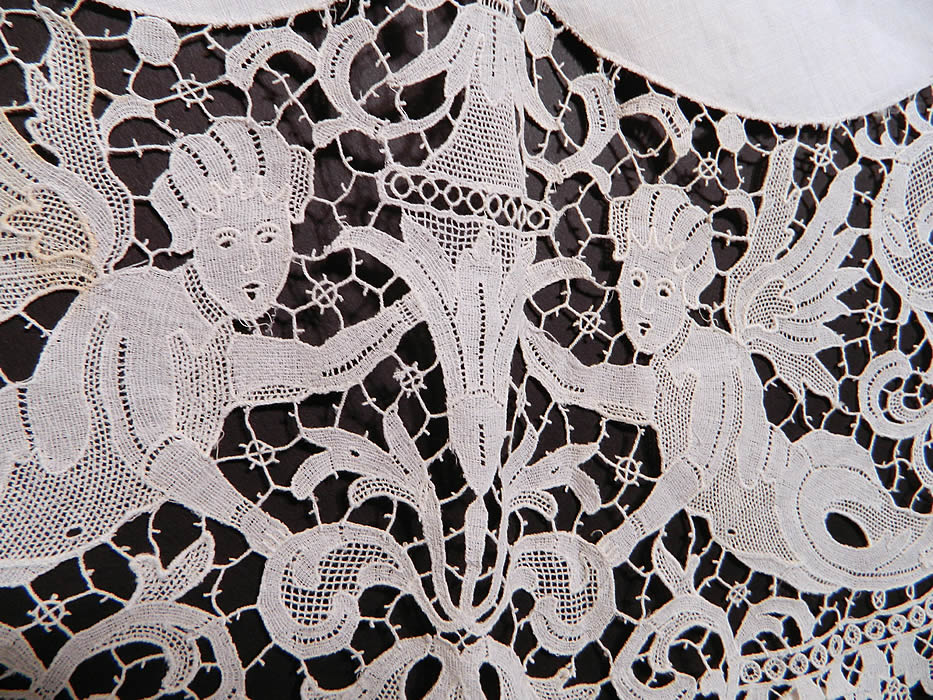 Victorian Antique Point de Venise Lace Renaissance Cupid Linen Round Tablecloth.  It is in good condition, but has not been cleaned, with only a few tiny faint age spot stains. This is truly a wonderful piece of antique lace textile art!