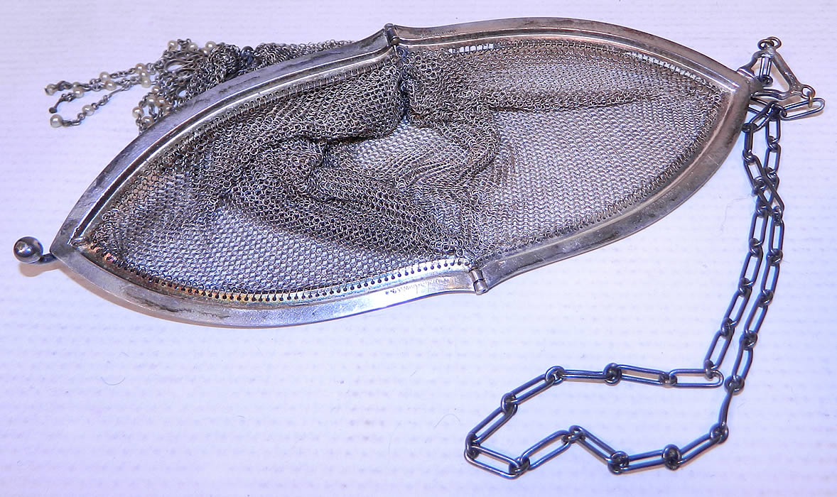 Vintage Whiting & Davis Co Silver Mesh Chainmail Flapper Purse
This fabulous flapper handbag purse has a long oval shape, with silver plated frame stamped inside "Whiting & Davis Co.", a ball clasp closure on top, chainlink carrying strap and is sheer, unlined. The purse measures 7 inches long and 3 inches wide.
