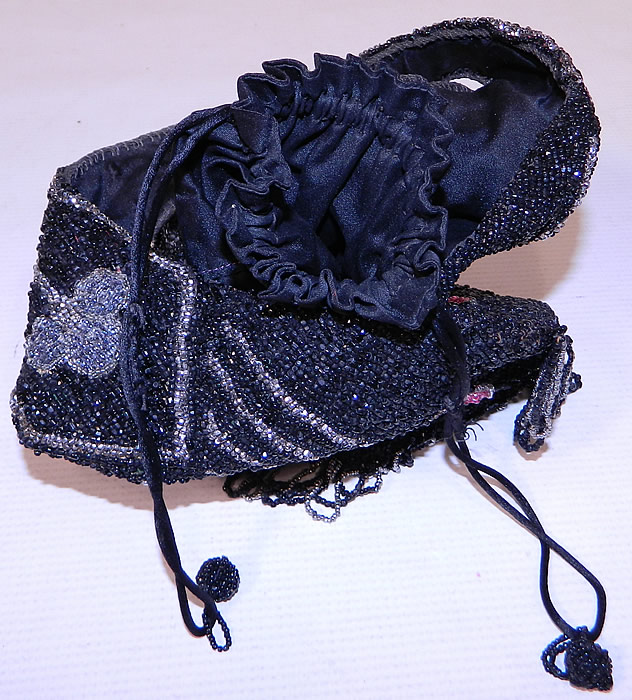 Vintage Art Deco Black & Silver Beaded Fringe Drawstring Flapper Purse
This fabulous flapper handbag purse has an inner black silk drawstring closure with silk rope ties, beaded ball trim ends and a beaded arm loop strap on top for carrying.