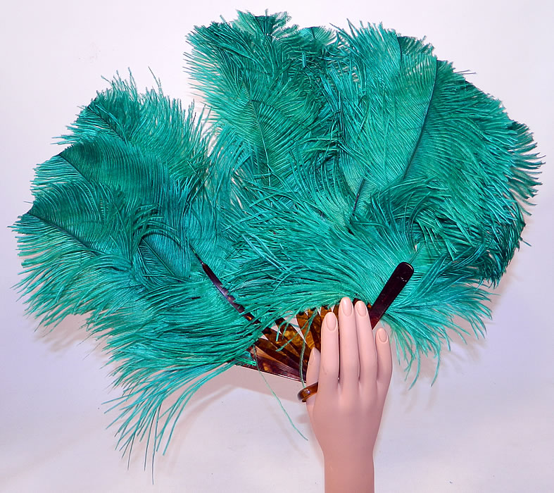 Vintage Art Deco Teal Blue Green Ostrich Feather Folding Flapper Fan
This fabulous flapper fan measures 16 inches long and 30 inches wide when opened. It is in good condition. This is truly a wonderful piece of feather art!
