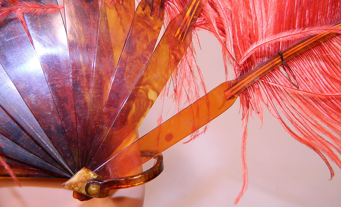 Vintage Art Deco Red & Pink Ostrich Feather Folding Fixed Flapper Fans
It measures 24 inches long and 10 inches wide. The other fan is made of a dyed reddish orange color fluffy ostrich feather plumes. This fabulous flapper folding fan has faux tortoise shell celluloid sticks, guards and loop rivet on the bottom. 
