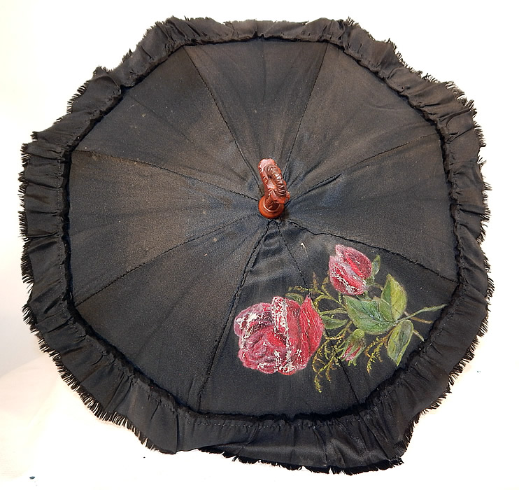 Victorian Black Silk Hand Painted Roses Grape Leaf Wood Carved Handle Parasol
There is a decorative carved relief wood handle, with a three dimensional grape leaf vine design wrapped around it and finial top. This pretty parasol is lined in a white silk fabric. 